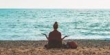 Achtsamkeit und Ruhe: Eine Frau meditiert am Strand