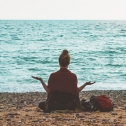 Achtsamkeit und Ruhe: Eine Frau meditiert am Strand